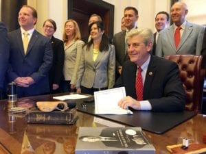 A group of people engaged in litigation, standing around a desk.