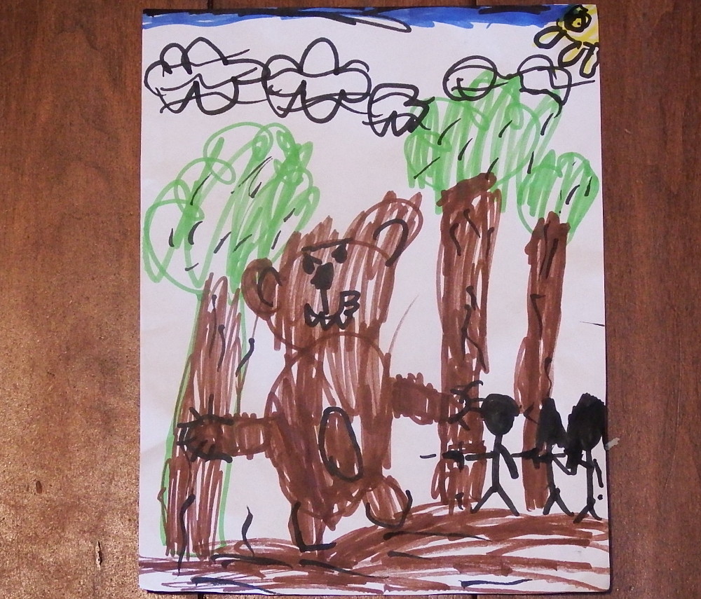 Child's drawing showing a large brown bear standing among trees with a sun and clouds in the sky. Stick figures of people are to the right of the bear are holding firearms.