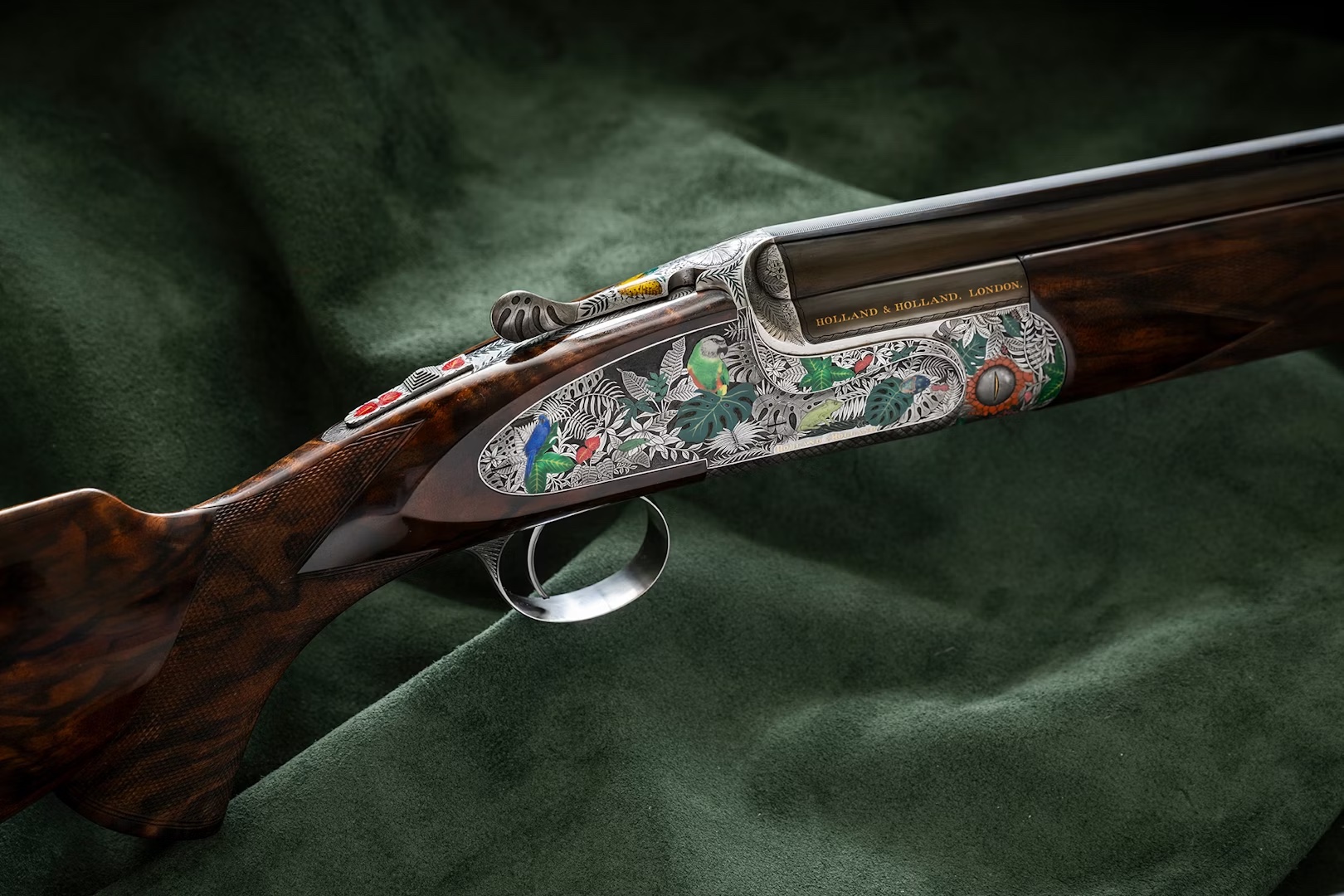 A detailed side view of a decorative shotgun with engravings and engravings, laying on a green cloth.