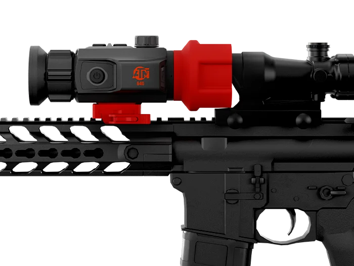 A black rifle with a mounted ATN 640 digital optic scope highlighted in red on the scope's main body and mounting bracket.